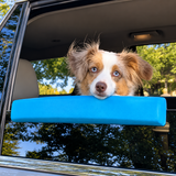 Blue dog car window chin rest installed on a vehicle window